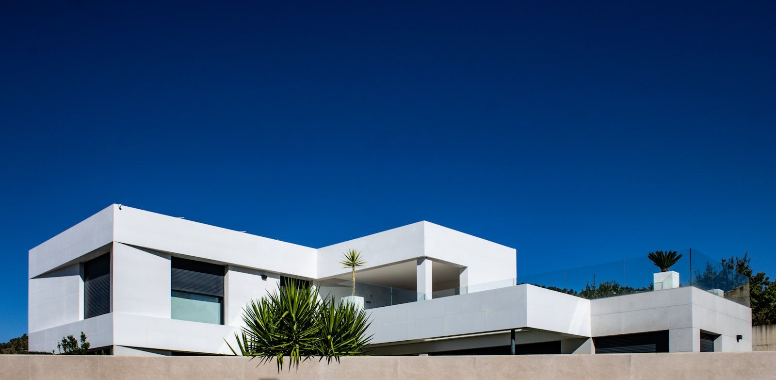 Modern residential home with an Acuasol solar water heater installed on the rooftop under a bright blue sky